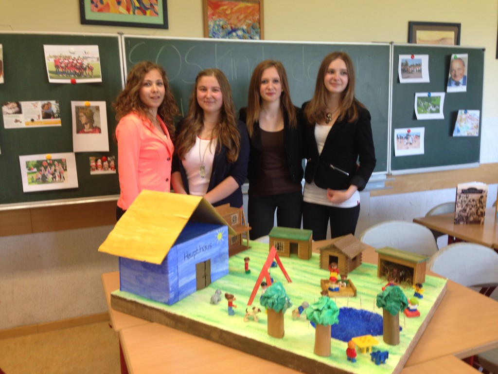 Anna-Maria, Sarah, Loreen, Alina vor Ihrem SOS-Kinderdorf-Modell